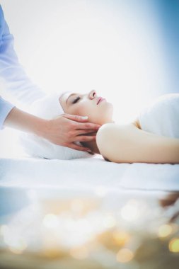 Masaj masasında uzanmış gözleri kapalı rahatlayan genç bir kadın. - Kadın. Spa salonu