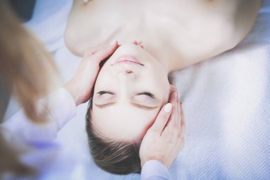 Masaj masasında uzanmış gözleri kapalı rahatlayan genç bir kadın. - Kadın. Spa salonu