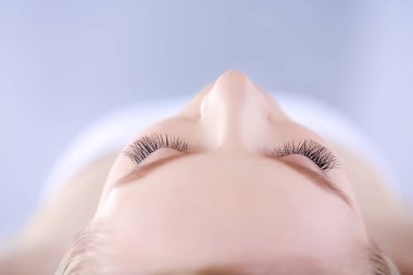 Masaj masasında uzanmış gözleri kapalı rahatlayan genç bir kadın. - Kadın. Spa salonu