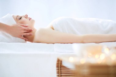 Masaj masasında uzanmış gözleri kapalı rahatlayan genç bir kadın. - Kadın. Spa salonu