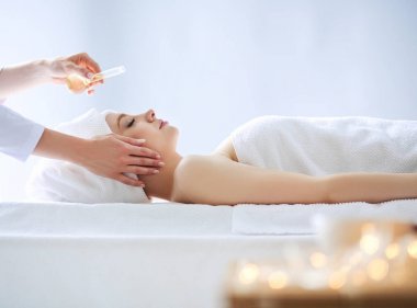 Masaj masasında uzanmış gözleri kapalı rahatlayan genç bir kadın. - Kadın. Spa salonu