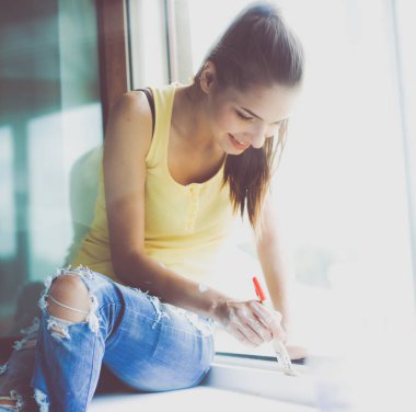 kadın boyama duvar bir apartman pencere çerçevesi dikkatli bitirme fırça ile