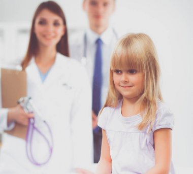 Kadın doktor ameliyatta steteskopla çocuğu muayene ediyor.