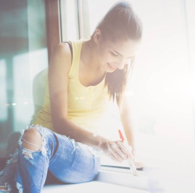 kadın boyama duvar bir apartman pencere çerçevesi dikkatli bitirme fırça ile