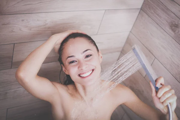 Jeune femme belle sous la douche dans la salle de bain . — Photo