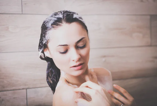 Junge schöne Frau unter der Dusche im Badezimmer. — Stockfoto