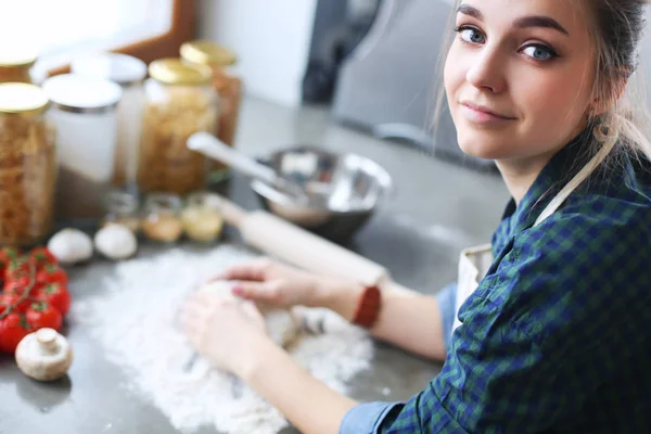 Jeune femme debout près de la cuisinière dans la cuisine . — Photo