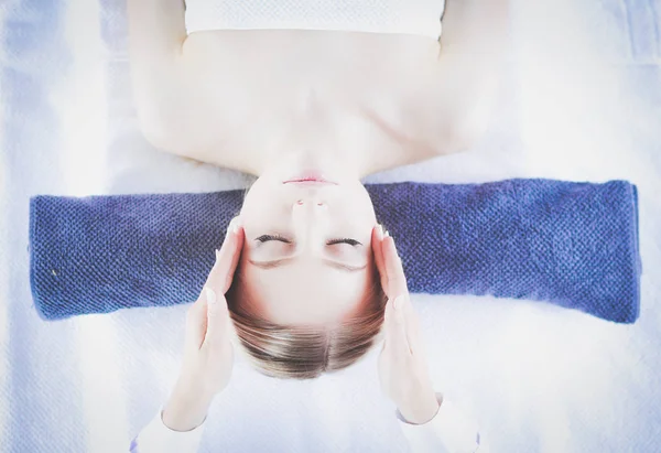 Mujer joven acostada en una mesa de masaje, relajándose con los ojos cerrados. Una mujer. Salón de spa — Foto de Stock