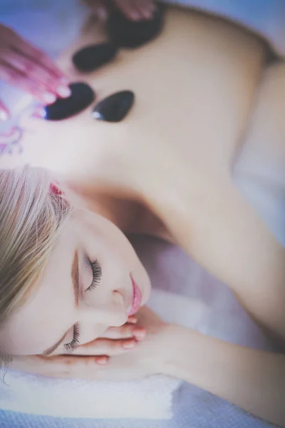 Mujer joven acostada en una mesa de masaje, relajándose con los ojos cerrados. Una mujer. Salón de spa — Foto de Stock