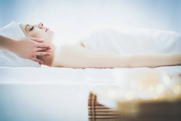 Jonge vrouw liggend op een massagetafel, ontspannend met gesloten ogen. Vrouw. Kuuroord — Stockfoto