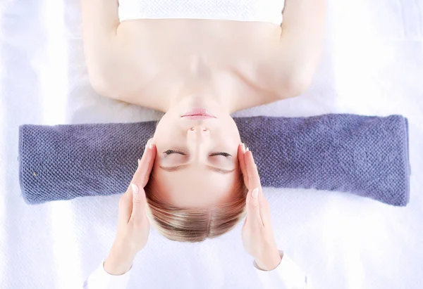Masaj masasında uzanmış gözleri kapalı rahatlayan genç bir kadın. - Kadın. Spa salonu