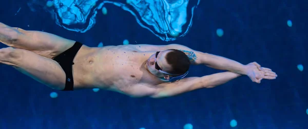 Mužský plavec u bazénu. Podvodní fotografie. — Stock fotografie