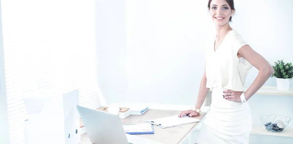 Attraktive Geschäftsfrau steht an Wand im Büro — Stockfoto