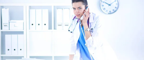 Fiatal nő orvos fehér kabátban a számítógép segítségével telefon — Stock Fotó