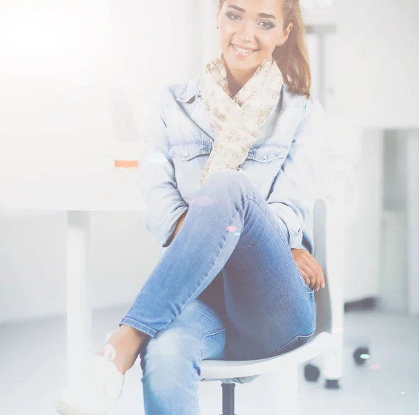 Aantrekkelijke jonge vrouw permanent in de buurt van tabel in office — Stockfoto