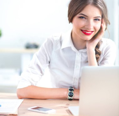 Ofiste masa başında oturan çekici bir iş kadını.