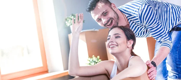 Feliz jovem casal desembalagem ou embalagem caixas e se mudar para uma nova casa — Fotografia de Stock