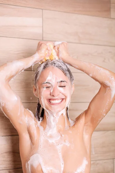 Jonge beautyful vrouw onder de douche in de badkamer. — Stockfoto