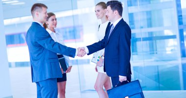 İki başarılı iş adamının el sıkışırken tam boy görüntüsü.