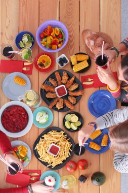 İnsanlar içecekler yemek masasında otururken. Masaya yiyecek. Masaya yiyecek. İnsanlar hızlı yemek yemek.