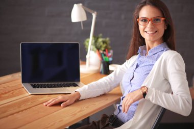 Masada oturan genç bir kadın..