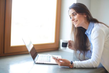 Resepsiyon yakınındaki genç kadın ayakta. Kadın mutfakta. Çalışma alanı