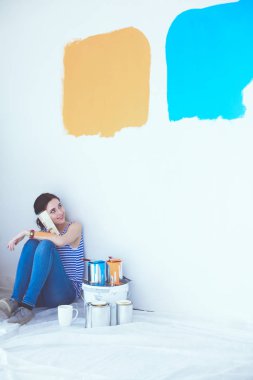 Kadın seçerek boya rengi renk örneği yeni ev ahşap yere oturmak için. Kadın evde