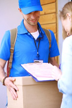 Mavi üniformalı gülümseyen kurye servis konseptine paket kutusu teslim eden teslimatçı. Mavi üniformalı gülümseyen teslimatçı.