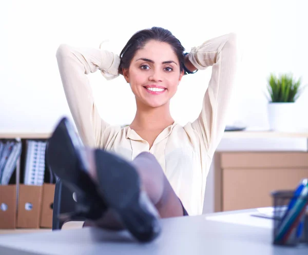 Geschäftsfrau entspannt sich mit den Händen hinter dem Kopf und sitzt auf einem Bürostuhl — Stockfoto