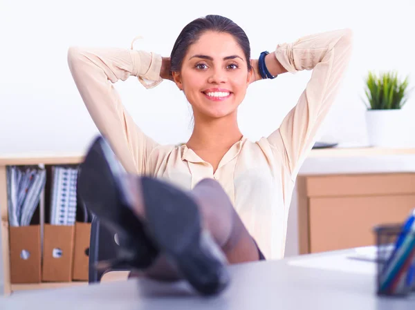 Mujer de negocios relajándose con las manos detrás de la cabeza y sentada en una silla de oficina — Foto de Stock