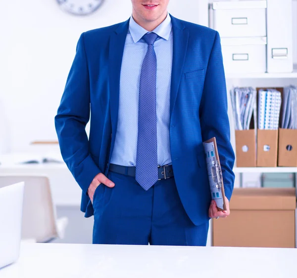 Üzletember vagy menedzser áll az asztalánál az irodában — Stock Fotó
