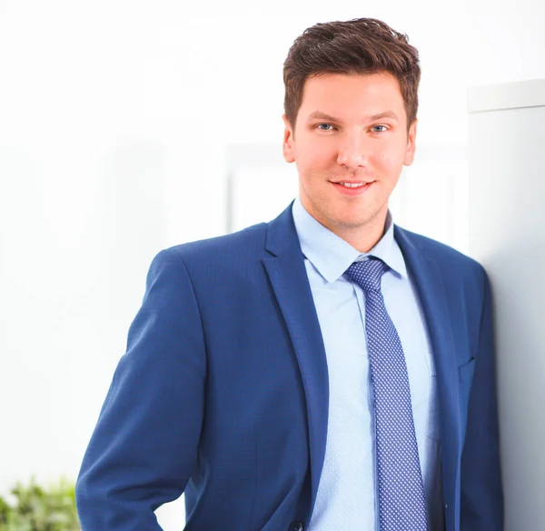 Business man or manager standing against his desk at office with  arms folded — Stock Photo, Image