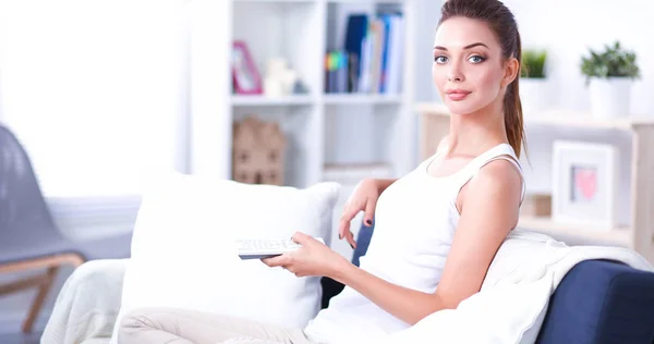 Retrato de una mujer joven viendo la televisión en casa — Foto de Stock