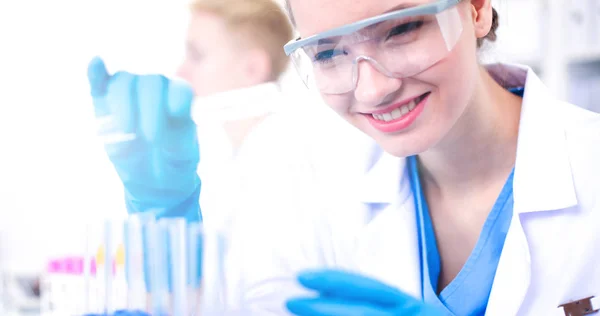 Woman researcher is surrounded by medical vials and flasks, isolated on white background — Stock Photo, Image