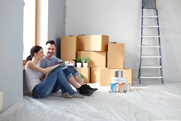 Portrait happy smiling young couple painting interior wall of new house. Young couple — Stock Photo, Image