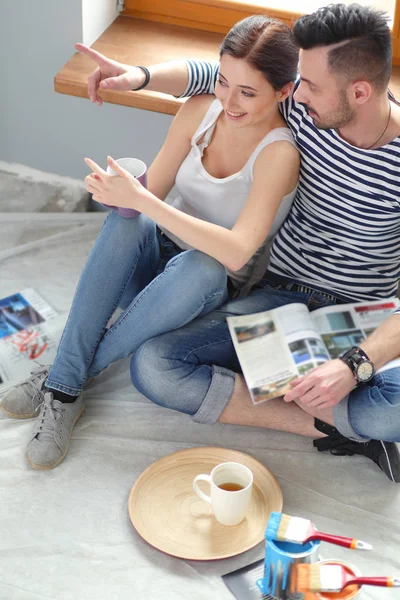 Pareja moviéndose en casa sentada en el suelo. Pareja. — Foto de Stock