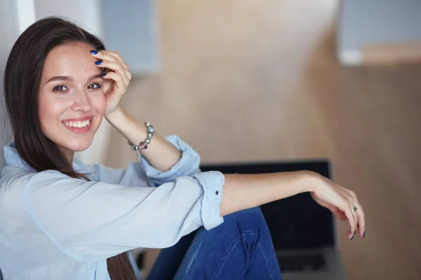 Mooie jongedame thuis zittend op de vloer met laptop. Mooie jongedame. — Stockfoto