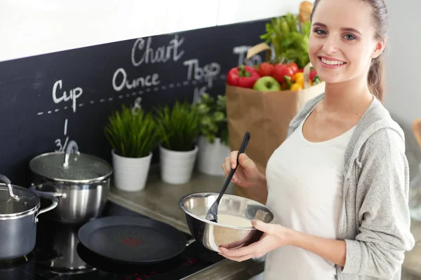 Genç bayan masanın yanında dururken mutfakta krep hazırlıyor. Mutfaktaki kadın. Mutfakta yemek yapmak..