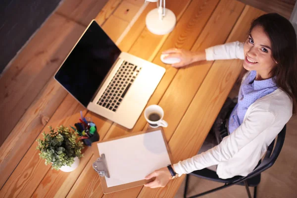 Masasında oturan ve elinde bir fincan kahveyle rahatlamış genç bir kadının portresi. İş kadını. İşyeri