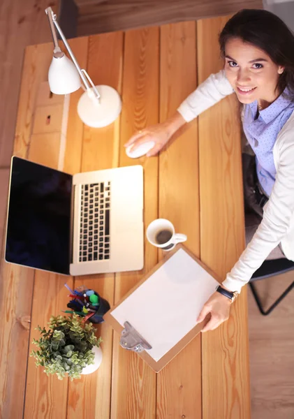 Masasında oturan ve elinde bir fincan kahveyle rahatlamış genç bir kadının portresi. İş kadını. İşyeri