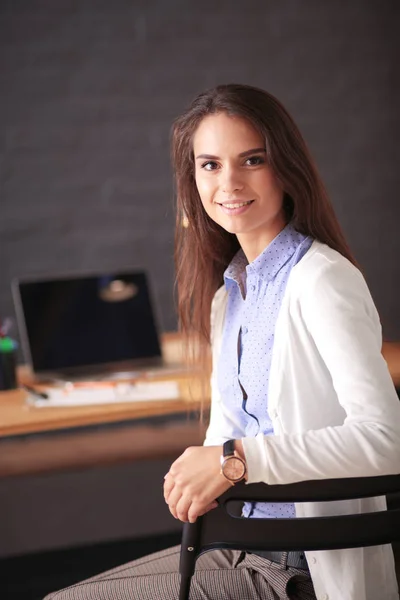 Jonge vrouw werkend zittend aan een bureau. — Stockfoto