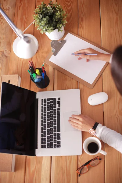 Jeune femme travaillant assise à un bureau. — Photo