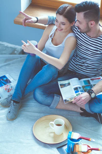 Par som flyttar i huset sitter på golvet. Par — Stockfoto