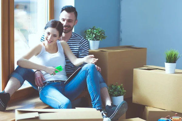 Couple moving in house sitting on the floor . Couple