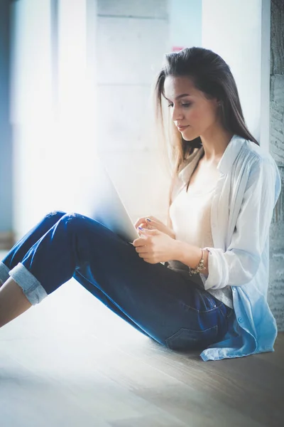 Young beautiful woman at home sitting on the floor with laptop. Young beautiful woman. — Stock Photo, Image