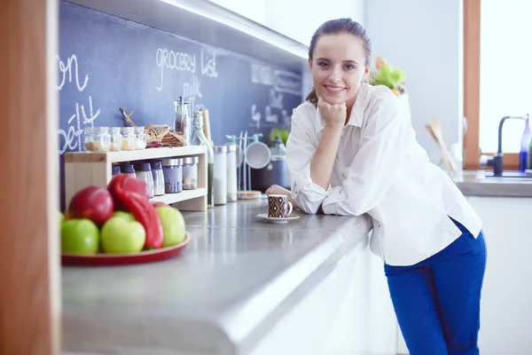 Portrait de jeune femme debout sur fond de cuisine . — Photo