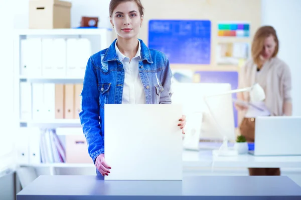 Two young woman standing near desk with instruments, plan and laptop. — Stock Photo, Image