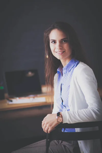 Jonge vrouw werkend zittend aan een bureau. — Stockfoto