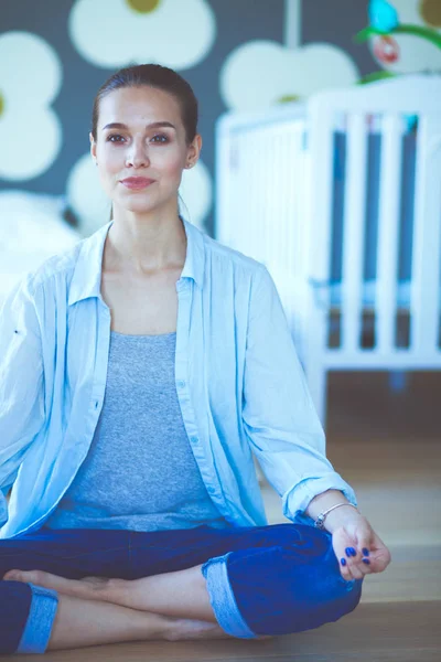 Mujer joven haciendo yoga en casa en la posición de loto. Mujer joven haciendo yoga . —  Fotos de Stock