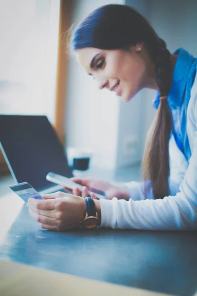 Junge Frau steht neben Schreibtisch. Frau in der Küche. Arbeitsplatz — Stockfoto